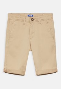 Beige Baumwollshorts mit geradem Schnitt, zwei Seitentaschen und umgeschlagenen Säumen. Mit einem braunen Knopf und einem blauen Markenlabel am Bund.