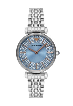 Silver-tone watch with a blue dial, surrounded by sparkling crystals, featuring a stainless steel bracelet and minimalist hour markers.