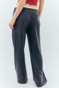 Tamno sivi široki pantaloni napravljeni od mekog materijala, sa teksturiranim završetkom, elastičnim strukom i detaljem zadnje džepa.