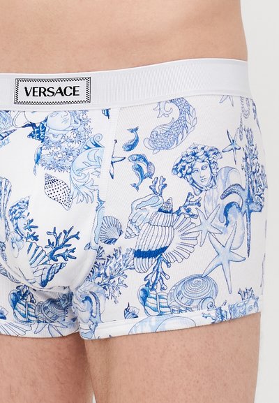 Boxer-briefs en coton blanc avec des motifs marins bleus, comprenant des coquillages, des poissons et du corail. Comprend une ceinture élastique de marque.