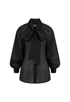 Zwarte shirt met een vlinderstrik-kraag, ballonmouwen en een wit stippenpatroon. Voorzien van knopen aan de voorkant en een licht doorschijnende textuur.