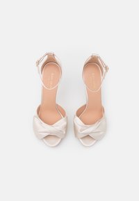 Light pink satin high-heeled sandals with a bow detail at the front and an ankle strap, featuring a smooth texture and open toe design.