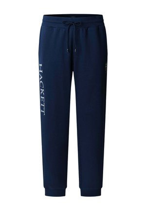Pantalones deportivos azul marino con cintura elástica y cordón, puños acanalados, texto blanco "HACKETT" en vertical en la pierna izquierda.