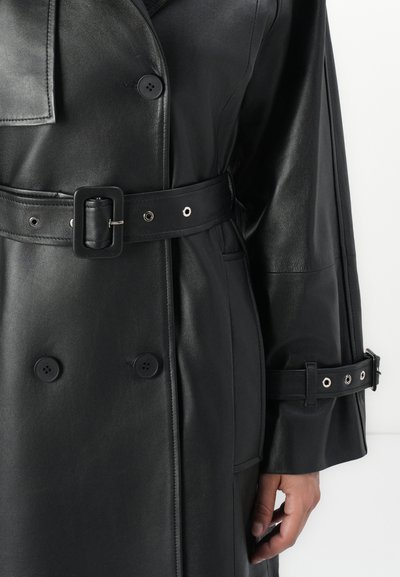 Black leather coat with a belted waist, double-breasted buttons, and a smooth texture. Features silver hardware on the belt and cuffs.