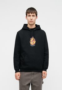 Μαύρη φούτερ με κουκούλα με μια μεγάλη, πολύχρωμη φλόγα και γραφικό στόμα στο κέντρο. Διαθέτει μπροστινή τσέπη και κουκούλα με κορδόνι. Μαλακή υφή.