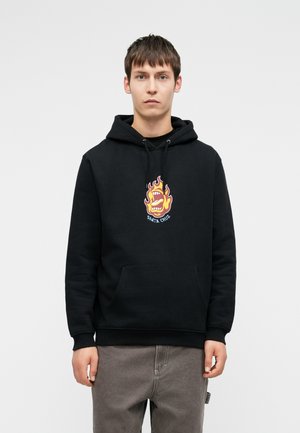 Μαύρη φούτερ με κουκούλα με μια μεγάλη, πολύχρωμη φλόγα και γραφικό στόμα στο κέντρο. Διαθέτει μπροστινή τσέπη και κουκούλα με κορδόνι. Μαλακή υφή.