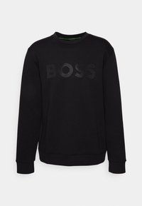 Svart långärmad sweatshirt med rundhals, som har ordet "BOSS" i stora perforerade bokstäver över bröstet.