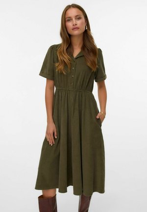 Robe vert olive avec un devant à boutons, des manches courtes retroussées, une taille cintrée et des poches latérales, fabriquée à partir d'un tissu doux et texturé.