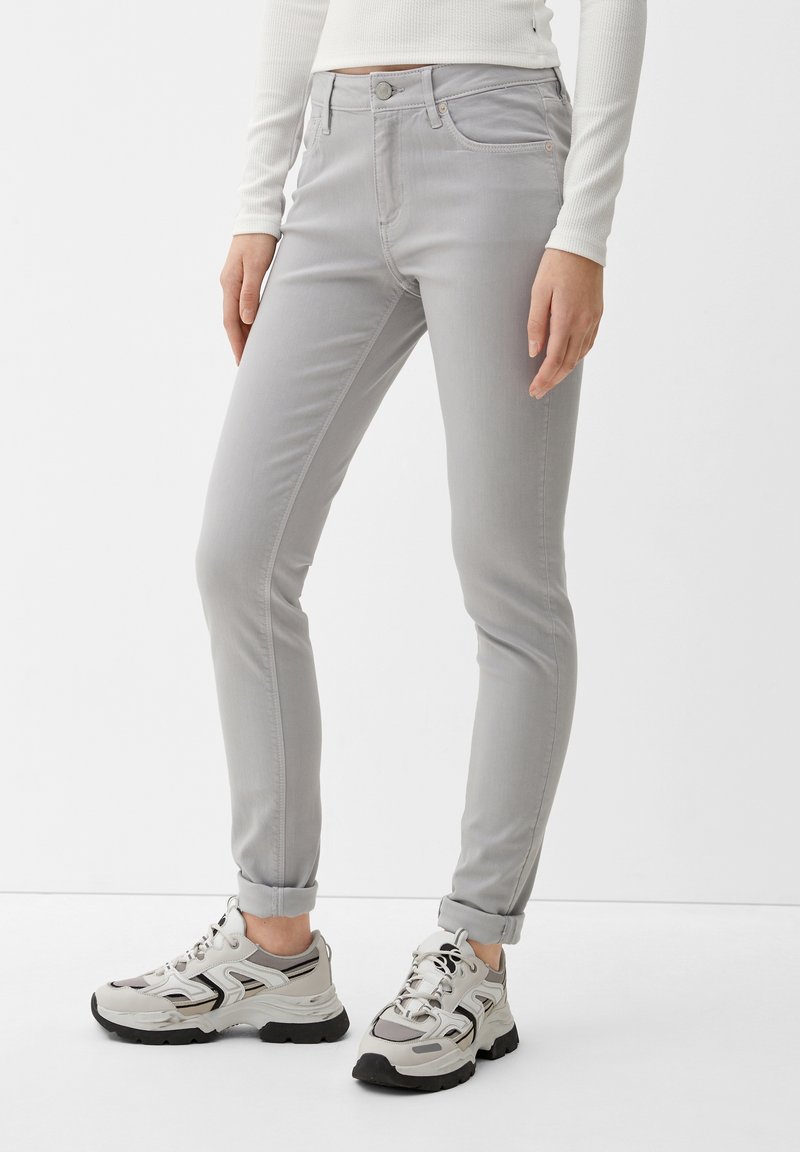 Jeans gris claro con un corte ajustado, estilo de cinco bolsillos y cintura de altura media. Con puños enrollados y una textura de tela suave con un detalle sutil.