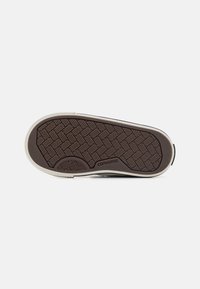 Smeđi gumeni potplat s teksturiranim uzorkom za grip, s bijelim rubom i vidljivim "Converse" logotipom. Ravni dizajn, praktičan za svakodnevno nošenje.