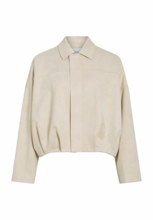 Kriauna be poros, su ilgomis rankovėmis, smailiomis apykaklėmis ir uždara priekyje, pagaminta iš minkštos zomšos tipo medžiagos.