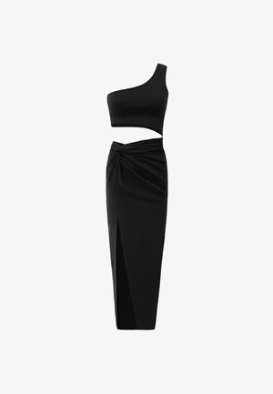 Ensemble noir en deux pièces comprenant un crop top asymétrique et une jupe taille haute avec un détail torsadé et une fente sur le côté. Tissu lisse.