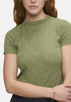 Grünes, kurzärmliges Rippenoberteil mit rundem Ausschnitt, kombiniert mit einer filigranen goldenen Kettenhalskette und einem passenden Armband, das mit Charms verziert ist.