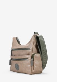 Bolso de cuero sintético beige con múltiples bolsillos con cremallera, de forma redondeada y con una correa verde ajustable. Detalle del logo en el frente.