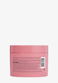 Un pot circulaire rose contient de la crème. Il présente une finition lisse et brillante avec un couvercle à vis. L'étiquette comprend des instructions d'utilisation multilingues et la liste des ingrédients.