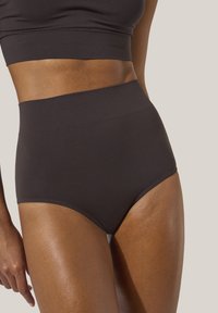 Högmidjade svarta trosor i mjukt, stretchigt material. Har en bred elastisk midjeband för komfort och en sömlös design.