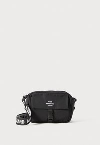 Black fabric crossbody bag with a flat shape, featuring a front flap, a buckle closure, and a logo strap. Smooth texture, minimal design.