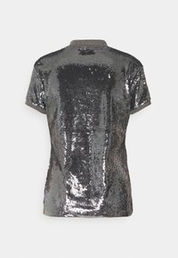 Camisa de manga corta con un diseño de lentejuelas en gris metálico, presenta un cuello acanalado y un acabado texturizado. La vista trasera muestra el patrón brillante.