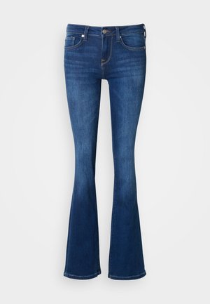 Granatowe dzwony jeansowe z denimu. Średni stan, pięciokieszeniowy krój z subtelnymi detalami przeszyć. Miękka faktura, dopasowane na udach.