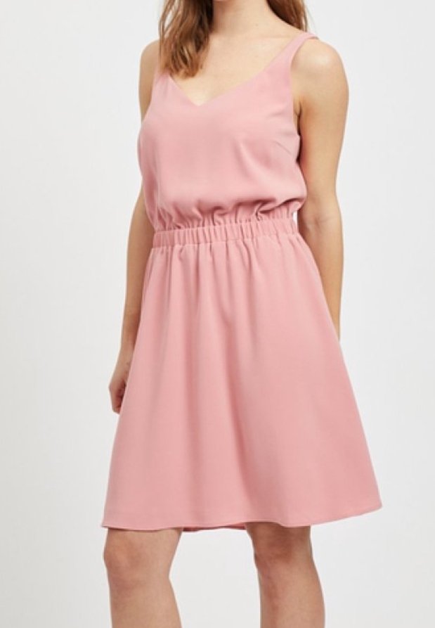 Robe rose sans manches avec un décolleté en V et une taille élastique. Le tissu semble lisse avec une silhouette fluide, se terminant au-dessus du genou.