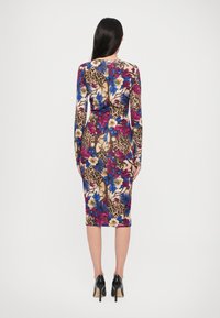 Langwijdige bodycon jurk met een multicolor bloemen- en luipaardprint, met een lengte tot halverwege de kuit en zwarte stilettohakken.