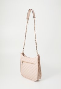 Quiltet beige håndtaske med kædetras og en udvendig lynlåslomme. Har en glat overflade og en buet silhuet for nem transport.