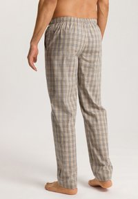 Geruite pyjamabroek met een elastische tailleband, met een beige basis kleur en blauwe en bruine lijnen, van lichtgewicht katoen.