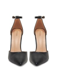 Pantofi cu toc înalt din piele neagră, cu vârf ascuțit și curea la glezne, având o textură netedă și un căptușel interior bej.