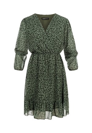 Vestido verde hasta la rodilla con manchas negras irregulares, escote en V, cintura ceñida, mangas largas transparentes y dobladillo con volantes.