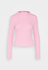 Sittande långärmad topp i ljusrosa ribbad tyg, med en vågig halsringning och nederkant. Slät textur med en lätt sträck.