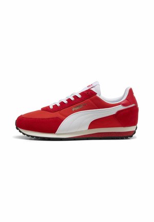 Baskets Puma rouges et blanches avec lacets blancs, semelle noire et logo doré Puma sur le côté, photographiées sur un fond blanc uni.