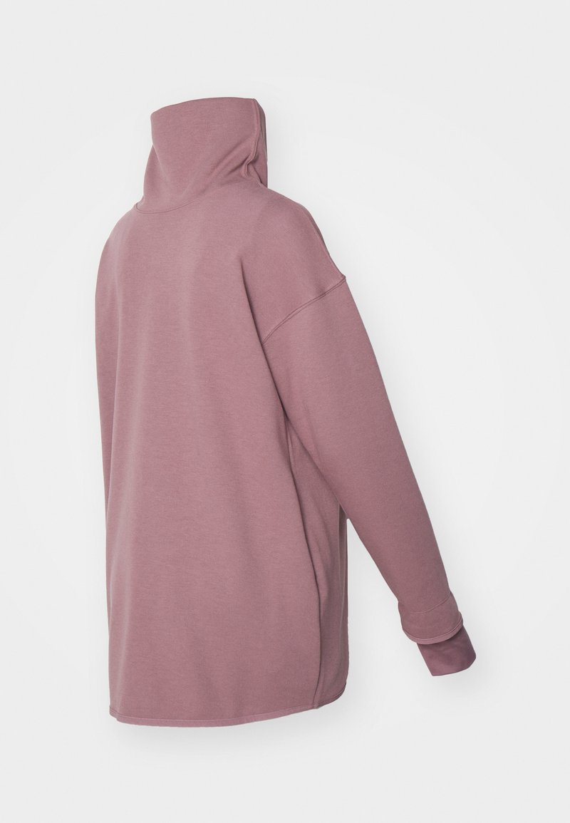 Overmaat pullover in stofroze kleur, met een hoge hals, verlaagde schouders en geribbelde manchetdetails, gemaakt van zachte, gestructureerde stof.