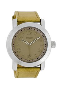 Montre ronde avec un boîtier en acier inoxydable argenté, cadran beige, grands chiffres arabes et un bracelet en cuir jaune texturé.