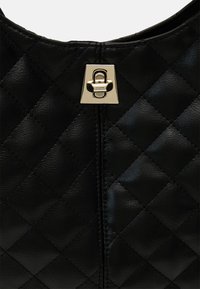 Czarna pikowana skórzana torba z złotym metalowym zapięciem. Posiada wzór w kształcie diamentu i gładką teksturę na powierzchni.