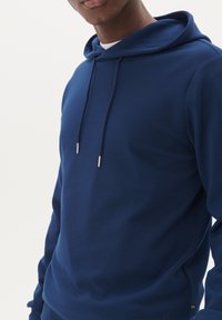 Felpa con cappuccio blu navy realizzata in tessuto morbido, caratterizzata da una vestibilità comoda, cappuccio regolabile con cordino e design minimalista.
