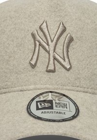 Sivá baseballová čiapka s vyšitým NY logom v metalickej béžovej farbe. Obsahuje nastaviteľný štítok veľkosti od New Era.