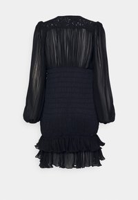 Black dress featuring a pleated design, ruffled hem, and smocked waist. Long sleeves and a lace-accented back add texture and detail.