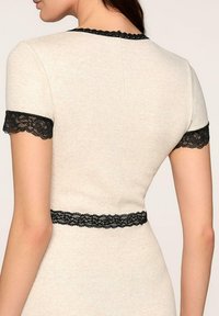 Jasnoszara sukienka z czarną koronką na rękawach i w talii, charakteryzująca się dopasowanym krojem i prążkowaną strukturą.