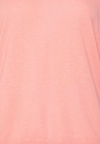 Jasnoróżowy dzianinowy sweter o miękkiej fakturze, szerokim dekolcie i luźnym kroju. Posiada ribbowe wykończenie u dołu i na mankietach.