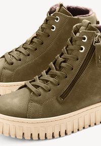 Baskets montantes en cuir vert olive avec une finition texturée, dotées de lacets plats, d'une fermeture éclair sur le côté et d'une semelle en caoutchouc beige épaisse.