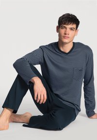 Marine gestreepte lange mouw shirt met een zak, gecombineerd met donkere broek, ontworpen voor comfort. Zachte stof en casual pasvorm.