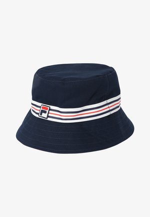 Sombrero tipo bucket azul marino con una banda a rayas blanca, roja y negra alrededor de la copa y una pequeña etiqueta rectangular con el logo.