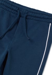 Pantaloni della tuta blu navy con vita elastica e stringi vita. Presentano una striscia laterale bianca e un tessuto morbido e strutturato.
