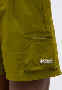 Olivově zelené šortky s boční kapsou na klopu a přišitou nášivkou s logem Columbia Sportswear Company.