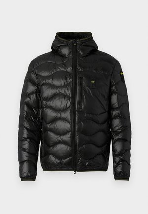 Zwarte pufferjack met een glanzende textuur, capuchon, ritsluiting en golvenpatroon. Voorzien van een borstzak en contrasterende gele accenten.