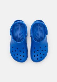 Blue plastic clogs featuring ventilation holes, textured footbed, curved back strap, and smooth finish. Rounded toe and heel.