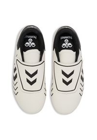 Hvide slip-on sportssko med sorte accenter, der har chevron-mønstre og en struktureret overdel. Sorte kanter og logo på tungen.