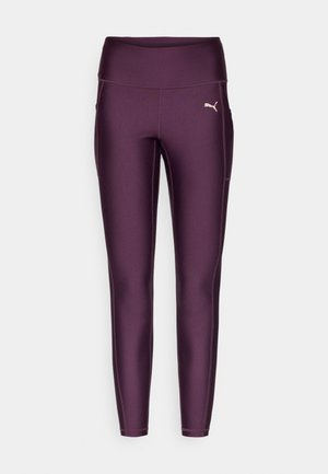 Leggings sportivi Puma di un profondo viola, con vita alta, texture liscia e tasche laterali. Presenti dettagli di cucitura a contrasto.