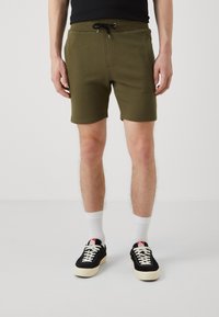 Olivengrønne bomuldsshorts med elastisk talje og snor. Har sidelommer og en enkel, glat tekstur.