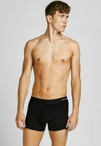 Schwarze Boxer Shorts aus dehnbarem Stoff, mit einem bequemen Taillenbund mit Branding und einem enganliegenden Design, das den Körper konturiert.